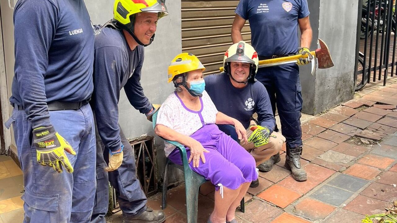 Luego del rescate, la mujer posó junto a los socorristas que la ayudaron a salir de la casa.