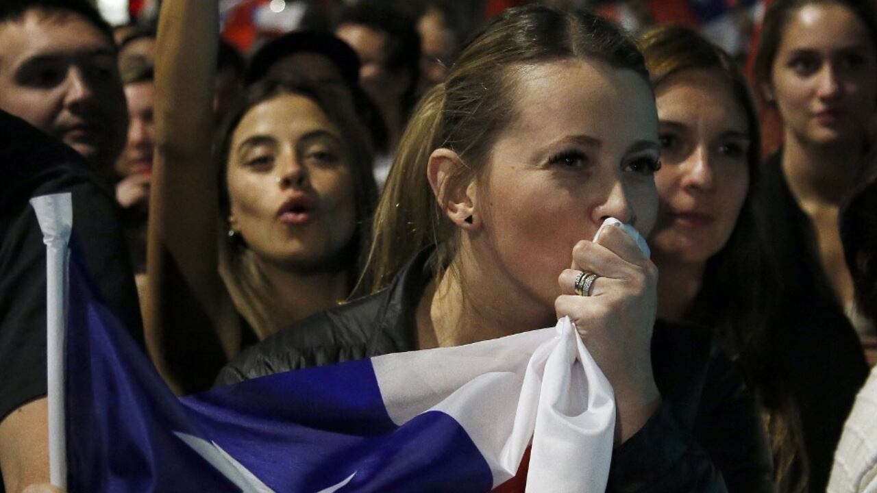 Una mujer celebra que en Chile haya ganado el NO a la nueva constitución y besa la bandera del país