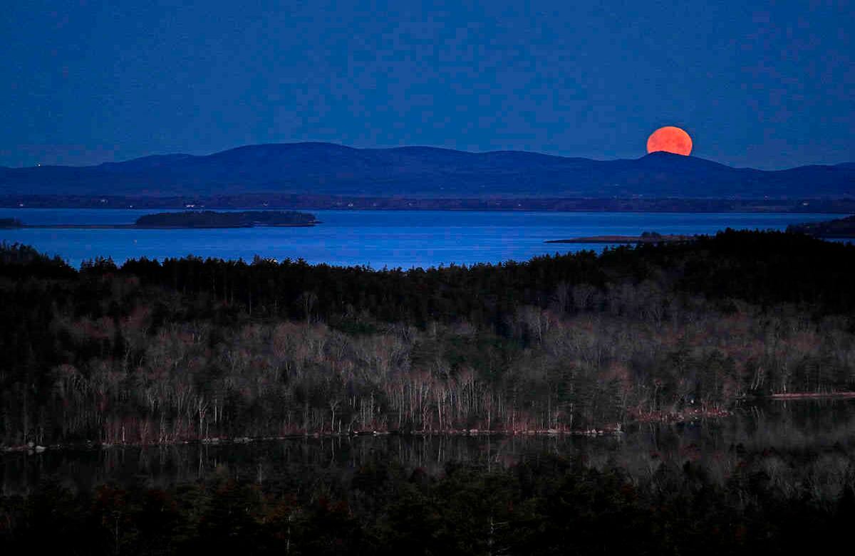 La luna casi llena se pone al amanecer detrás de Camden Hills en esta vista mirando hacia el oeste a través de Penobscot Bay, el miércoles 6 de mayo de 2020, cerca de Camden, Maine. Foto: Robert F. Bukaty/AP