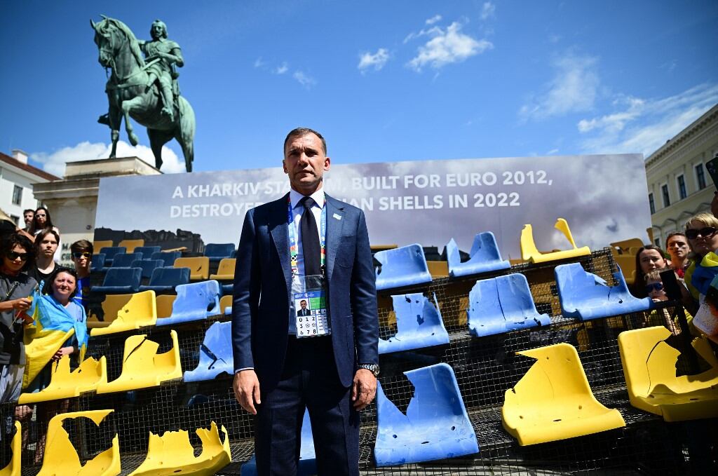 El presidente de la Asociación Ucraniana de Fútbol, ​​Andriy Shevchenko, posa frente a una instalación de asientos dañados con los colores de Ucrania tomada del estadio de fútbol Sonyachny en Kharkiv, Ucrania, el 17 de junio de 2024 en Munich, sur de Alemania. La instalación está dedicada a las instalaciones deportivas que fueron bombardeadas durante la guerra ruso-ucraniana. Járkov fue una de las ciudades que acogió el Campeonato Europeo de Fútbol UEFA Euro 2012. El estadio Sonyachny se construyó para esta competición y posteriormente se utilizó como campo de entrenamiento de la selección nacional de fútbol de Ucrania. Fue destruido por los bombardeos rusos en mayo de 2022. (Foto de Tobias SCHWARZ / AFP)