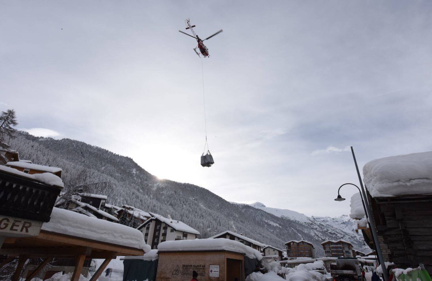 Un helicóptero trae ropa fresca para hoteles después de que fuertes nevadas y avalanchas atraparon a más de 13,000 turistas en Zermatt, que es una de las estaciones de esquí más populares de Suiza el 10 de enero de 2018. La nieve ha bloqueado todas las carreteras y el tren que conduce al complejo que también fue afectado por algunos cortes de energía. / AFP PHOTO / Mark Ralston.