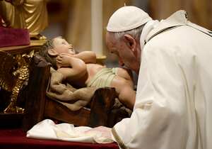El Papa Francisco besa una figura del niño Jesús durante la misa de Nochebuena en la Basílica de San Pedro en el Vaticano, el 24 de diciembre de 2021. (Photo by Filippo MONTEFORTE / AFP)