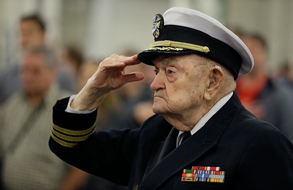 John Berger, capellán retirado de la Marina estadounidense, de 94 años de edad, saluda la bandera durante una ceremonia por el Día de los Veteranos . (AP)
