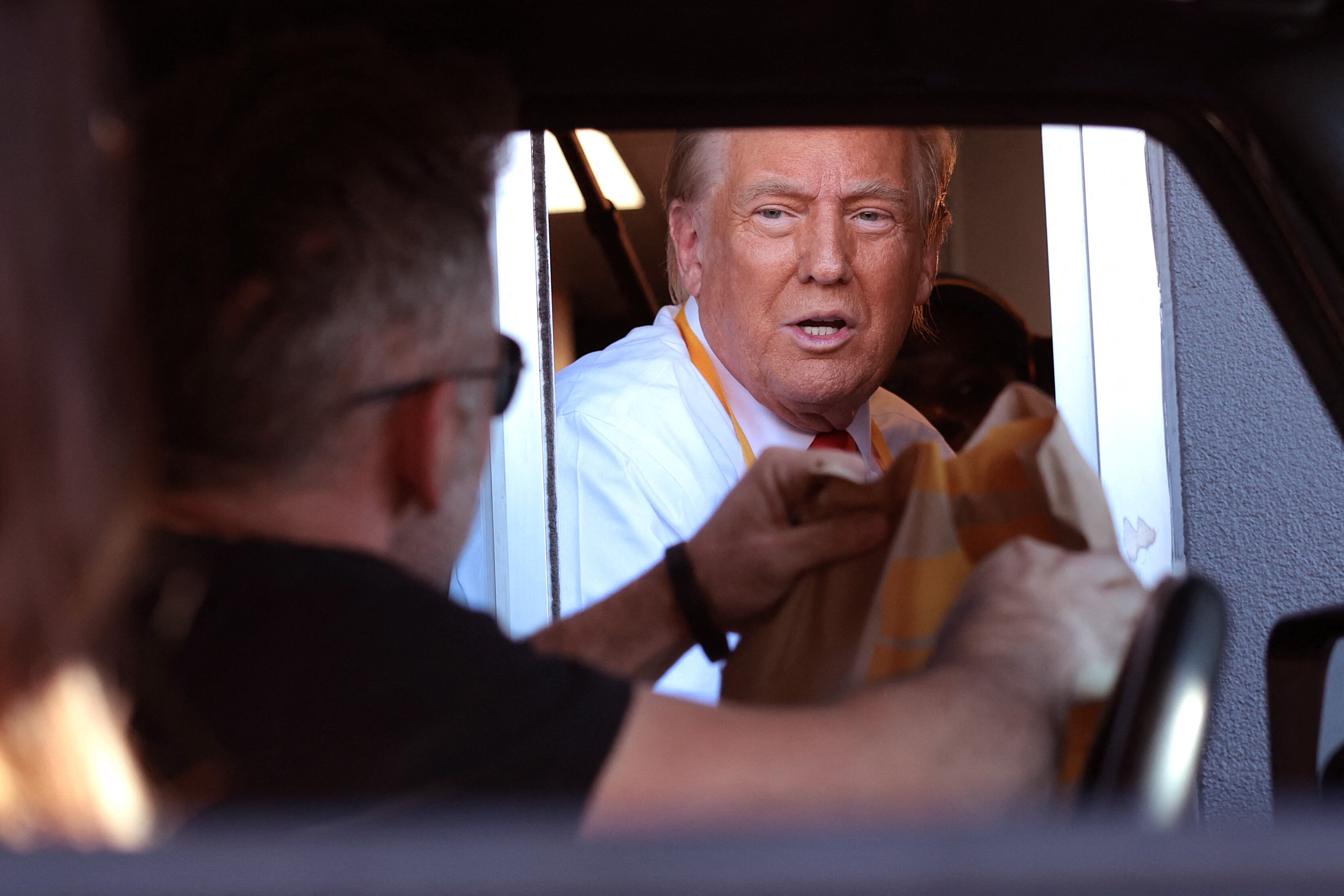 FEASTERVILLE-TREVOSE, PENNSYLVANIA - OCTOBER 20: Republican presidential nominee, former U.S. President Donald Trump works the drive-through line as he visits a McDonald's restaurant on October 20, 2024 in Feasterville-Trevose, Pennsylvania. Trump is campaigning the entire day in the state of Pennsylvania. Trump and Democratic presidential nominee Vice President Kamala Harris continue to campaign in battleground swing states ahead of the November 5 election.   Win McNamee/Getty Images/AFP (Photo by WIN MCNAMEE / GETTY IMAGES NORTH AMERICA / Getty Images via AFP)