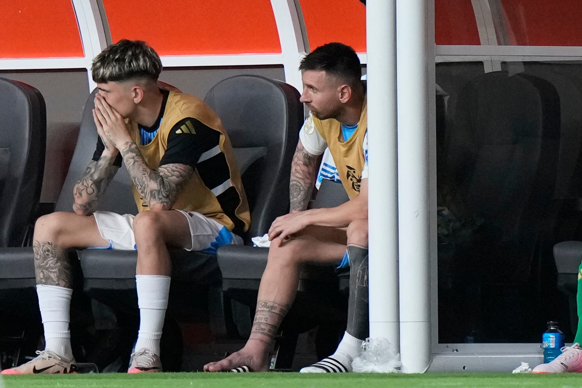 Argentina's Lionel Messi, right, sits on the bench after being substituted due to an injury during the Copa America final soccer match against Colombia in Miami Gardens, Fla., Sunday, July 14, 2024. (AP Photo/Wilfredo Lee)