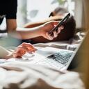 A teenage girl logging into an online zoom class using her laptop to study from her bedroom at home.