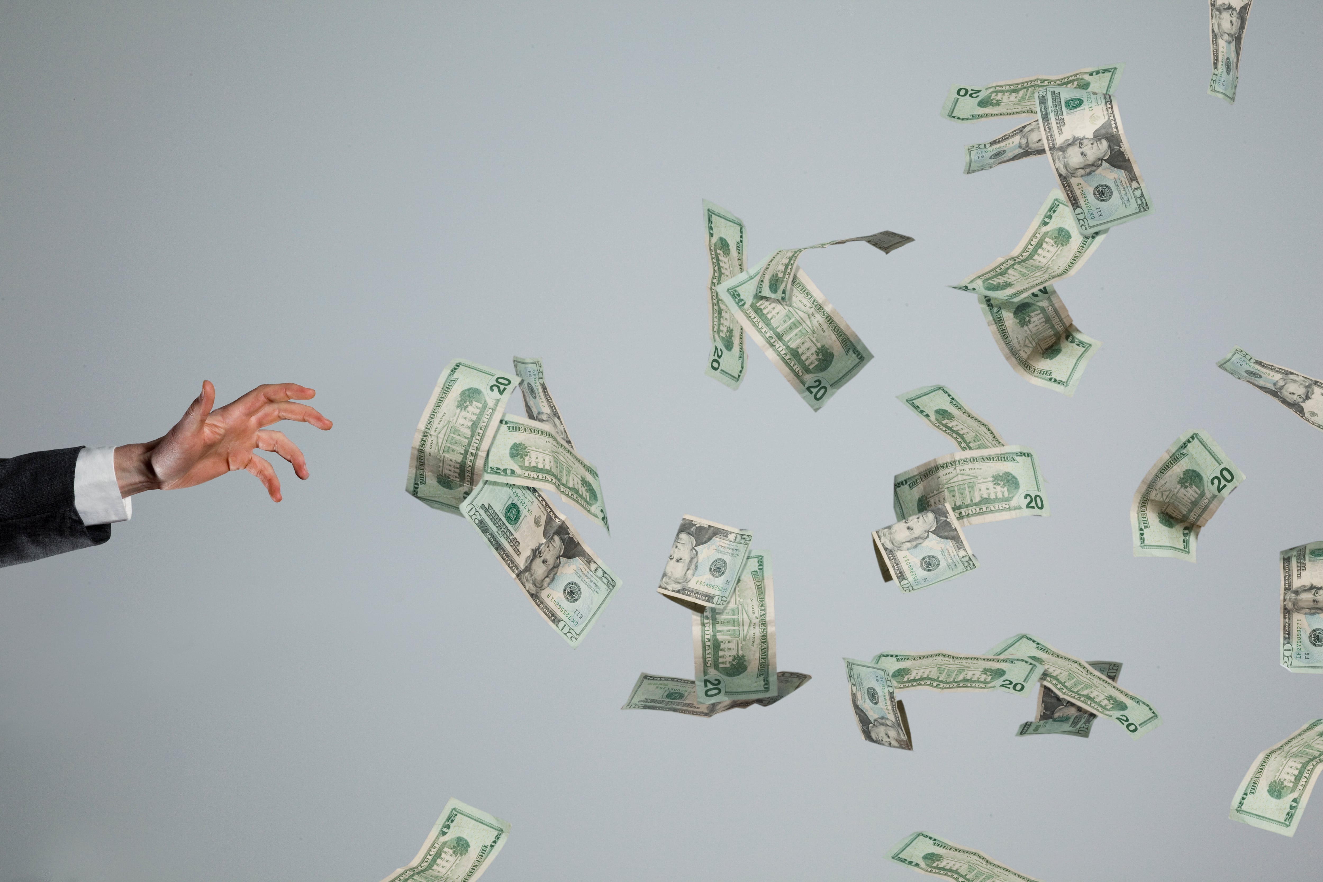 Hand grasping at fluttering money