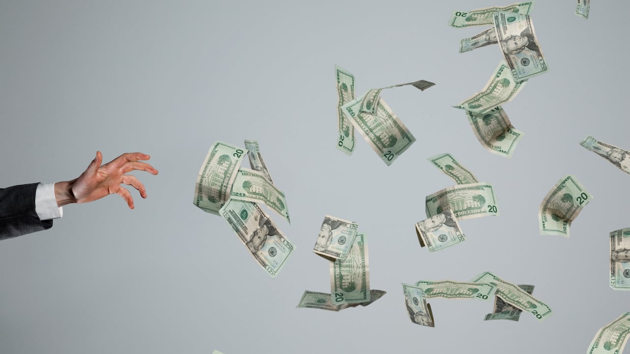 Hand grasping at fluttering money