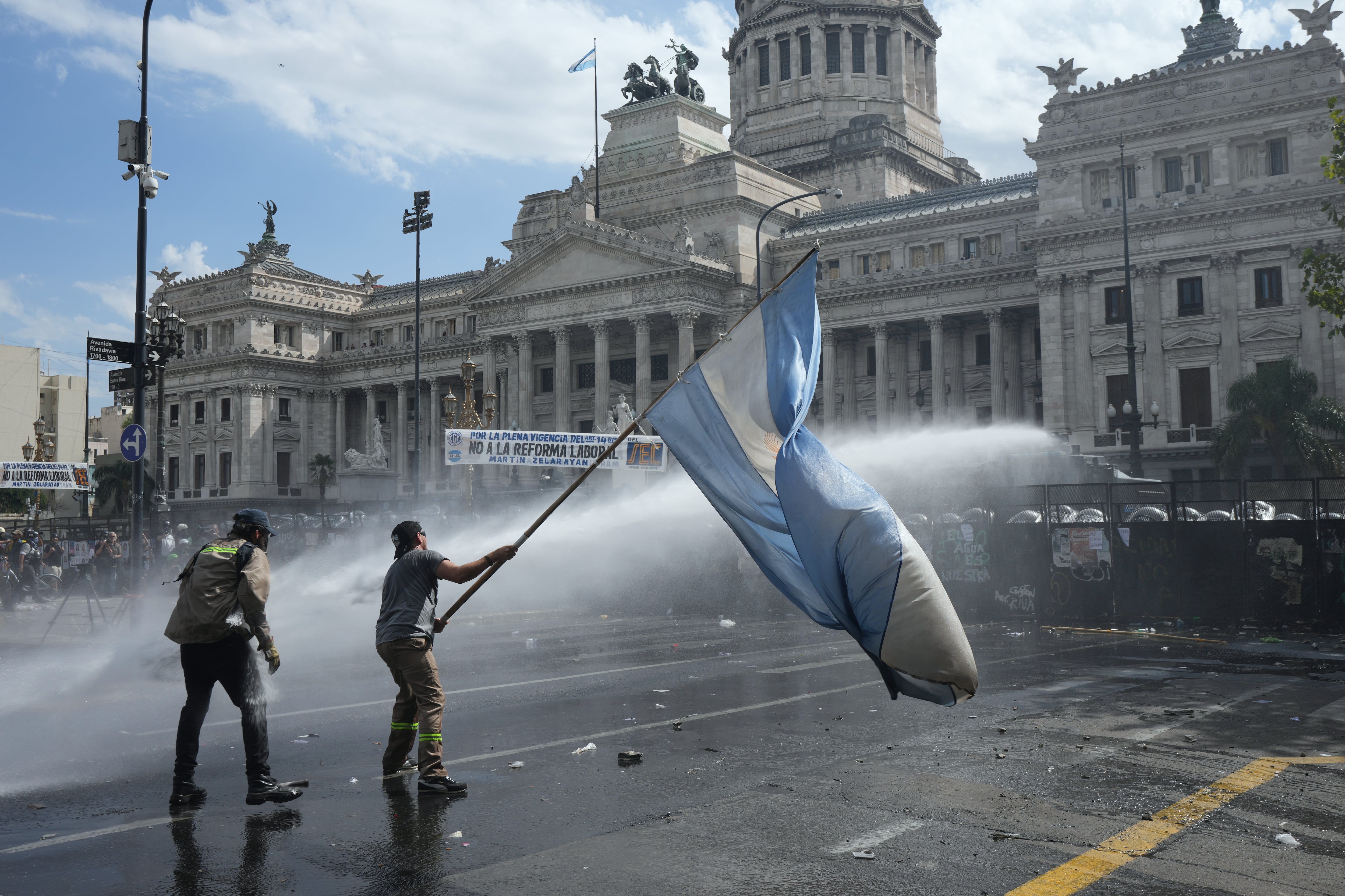 Un manifestante ondea una bandera durante una marcha de sindicatos y simpatizantes de la oposición contra un proyecto de ley de reforma laboral propuesto por el gobierno del presidente Javier Milei frente al Congreso en Buenos Aires, Argentina, el miércoles 11 de febrero de 2026.