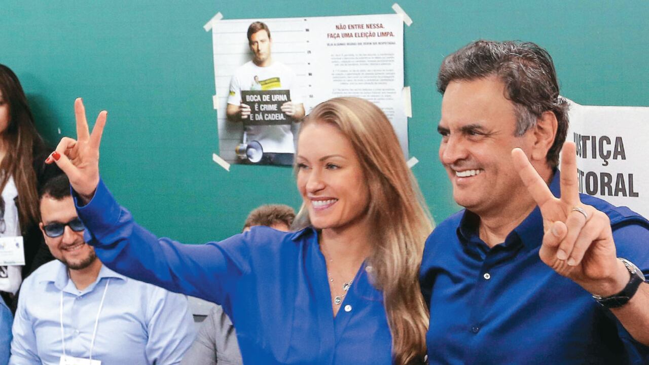 Neves fue la sorpresa al lograr un tercio del total de los votos. Hoy, lidera las encues-tas. En la foto, tras votar en primera vuelta con su es-posa, la exmodelo Leticia Weber.
