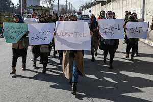 Mujeres sostienen pancartas durante una protesta para exigir el fin de las ejecuciones extrajudiciales de exfuncionarios del régimen anterior, en Kabul el 28 de diciembre de 2021. (Foto de Mohd RASFAN / AFP)