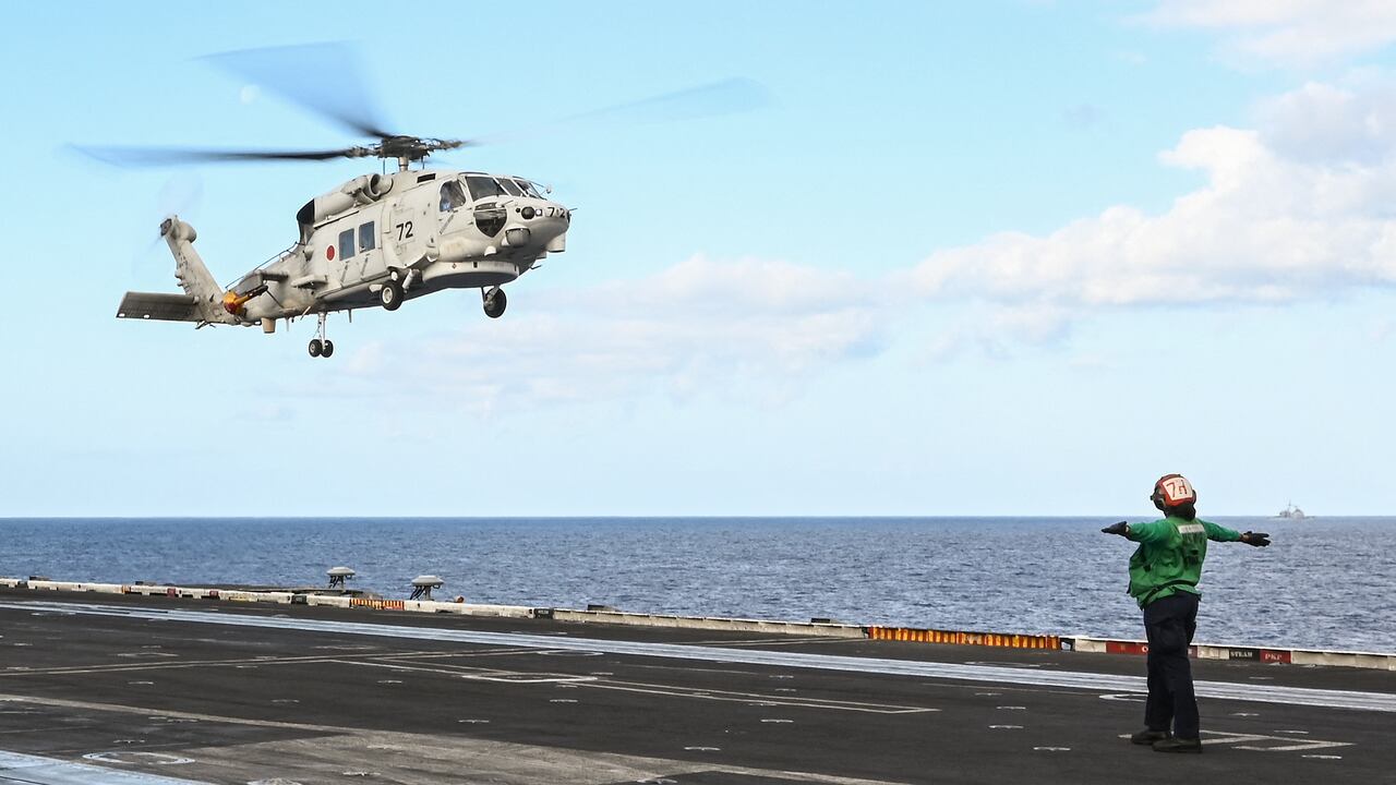 Esta foto tomada el 31 de enero de 2024 muestra un helicóptero SH-60K de la Fuerza de Autodefensa Marítima de Japón aterrizando en la cubierta del portaaviones USS Carl Vinson durante un ejercicio marítimo de tres días entre Estados Unidos y Japón en el Mar de Filipinas. Una importante operación de búsqueda continuó frente a Japón el 22 de abril de 2024 para buscar a siete personas desaparecidas después de que dos helicópteros SH-60K de la marina aparentemente chocaran durante el fin de semana, y se confirmó la muerte de un miembro de la tripulación.