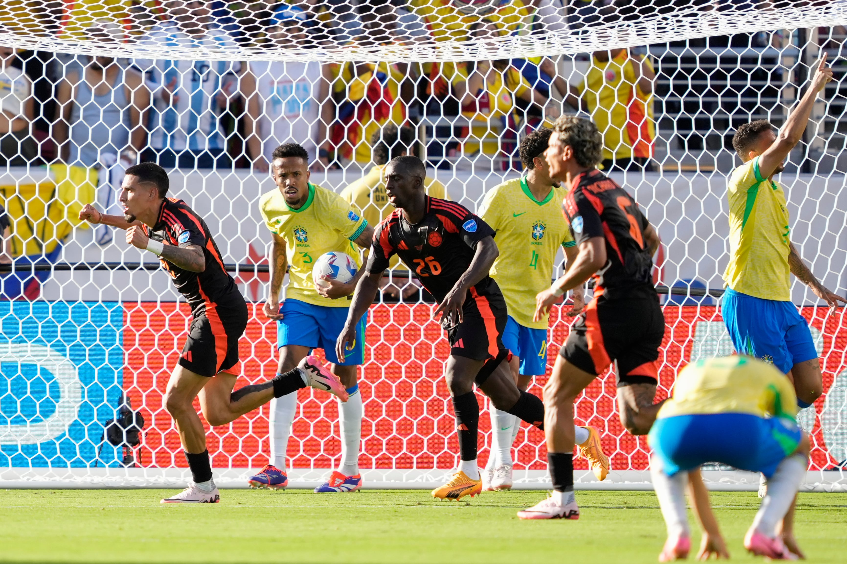 Colombia's Daniel Munoz, left, celebrates after scoring his side's first goal against Brazil during a Copa America Group D soccer match in Santa Clara, Calif., Tuesday, July 2, 2024. (AP Photo/Tony Avelar)