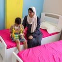 La abuela de Hind Rajab, una niña palestina de cinco años que quedó atrapada en un coche con miembros de su familia tras ser asesinados en enero de 2024 y que había pedido ayuda a los rescatadores antes de que se perdiera la comunicación con ellos, aparece sentada junto a su nieto, Iyad, hermano de Hind. Foto: Omar AL-QATTAA / AFP