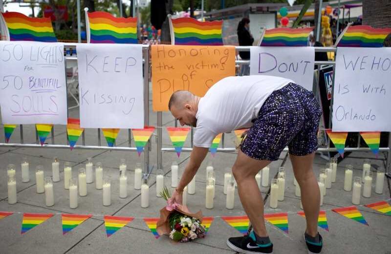 Rickey Swanson coloca un ramo de flores en una instalación de homenaje con 50 velas, en honor a los fallecidos en la masacre, durante un evento de orgullo gay en West Hollywood. Foto: Mindy Schauer/The Orange County Register via AP