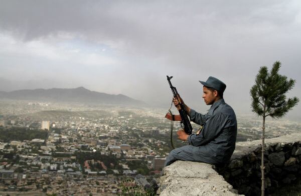 Un policía está sentado en un muro, a las afueras de Kabul, desde donde se visibiliza toda la capital de Afganistán. (AP)