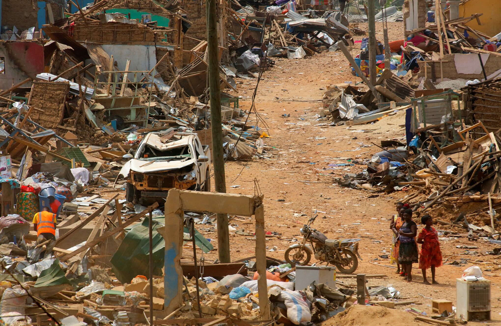La gente observa los daños causados cuando un vehículo que transportaba explosivos mineros detonó a lo largo de una carretera en Apiate, Ghana. Foto REUTERS/Francis Kokoroko