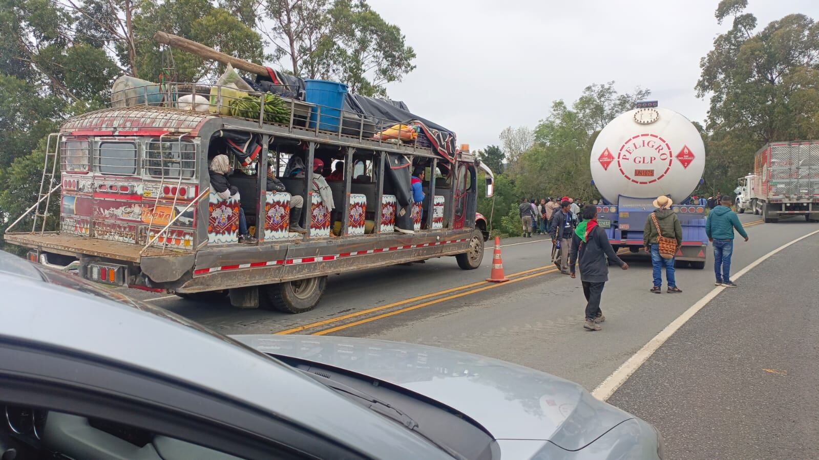 Los indígenas portan banderas alusivas al Cric mientras le impiden el paso a las tractomulas, las cuales algunas de ellas terminaron atravesadas sobre la carretera.