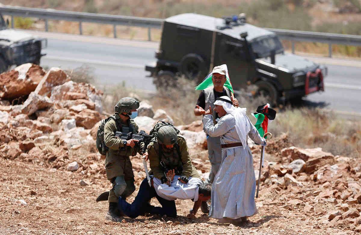 Soldados israelíes detienen a un palestino durante una protesta contra la expansión de los asentamientos israelíes en la aldea de Khirbet Jubara, cerca de la ciudad cisjordana de Tulkarm, el jueves 20 de agosto. Foto: Majdi Mohammed / AP
