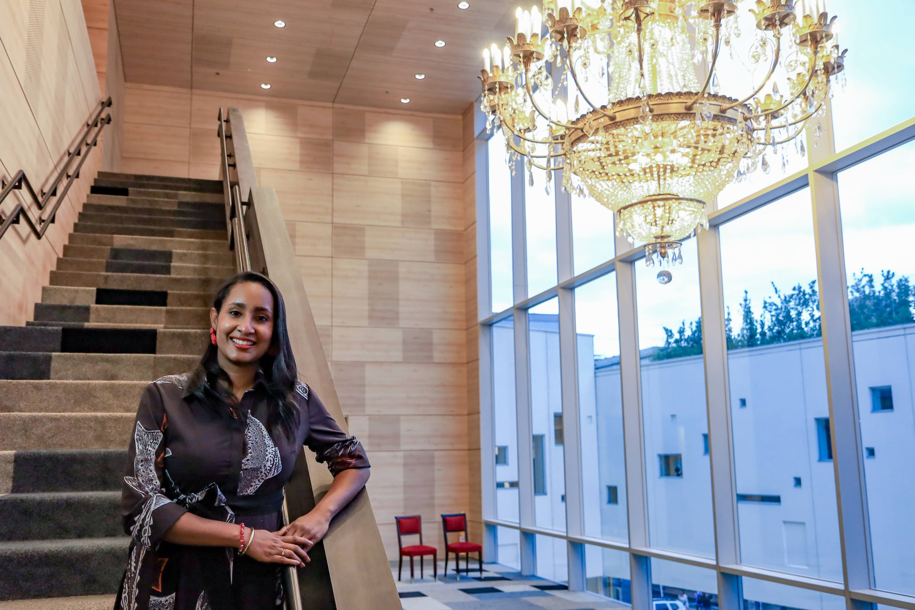 La ministra de Cultura, Angélica Mayolo, junto a la lámpara Cantini, original del Teatro Colón desde 1948. ahora en el vestíbulo de la sala Delia Zapata.