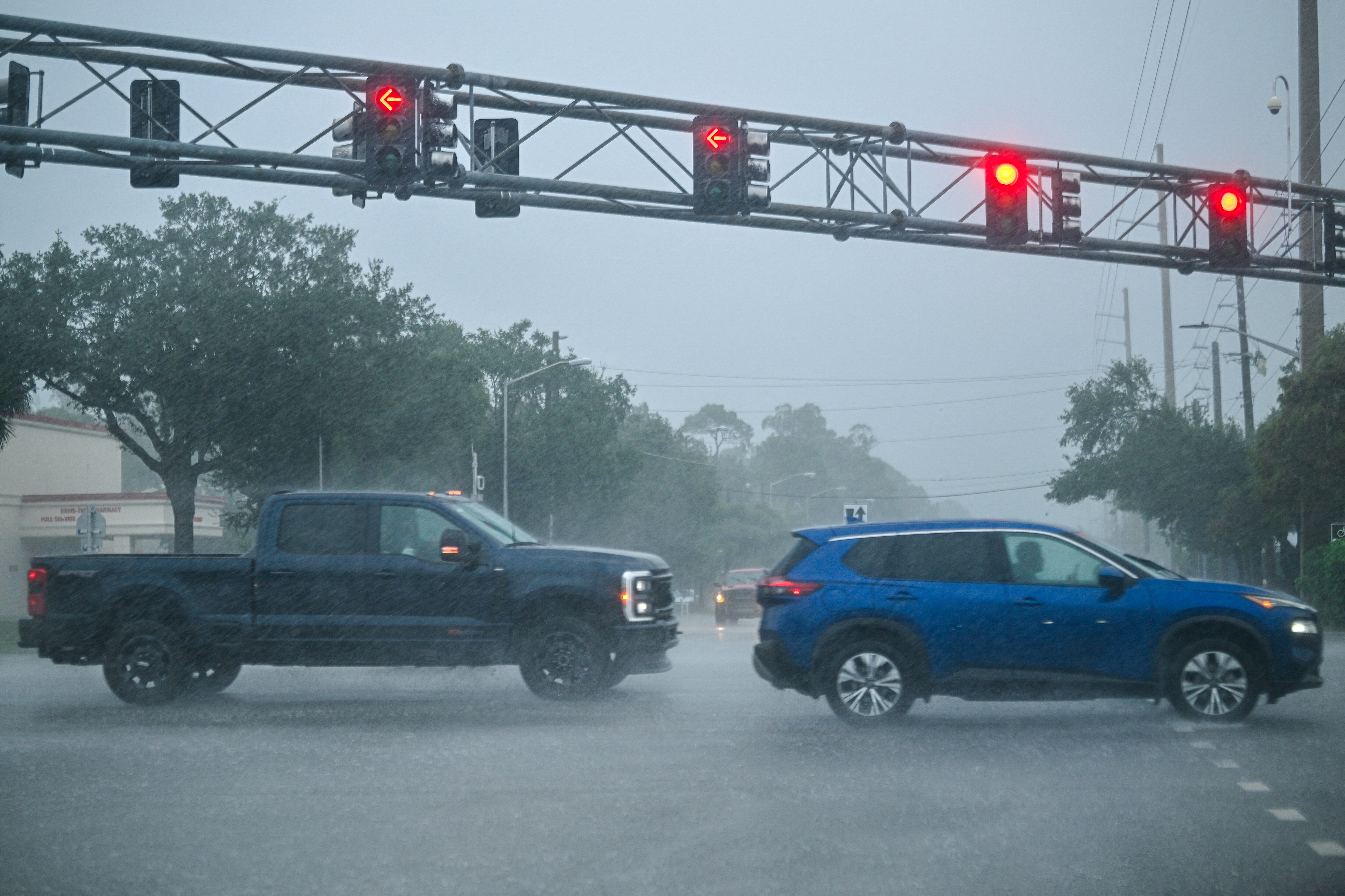 Los vehículos circulan bajo una intensa lluvia antes de que el huracán Milton toque tierra en Sarasota, Florida, el 9 de octubre de 2024.