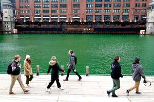 La gente camina por el Chicago Riverwalk el día de San Patricio, miércoles 17 de marzo de 2021. El río Chicago se tiñó de verde antes del Día de San Patricio. Foto: AP / Shafkat Anowar.