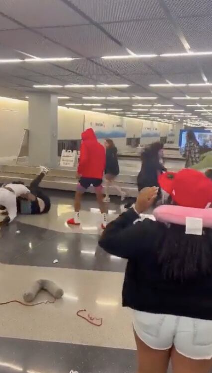 Momento en el que la mujer en el piso (pantalón negro) fue agredida por el hombre que viste camiseta blanca