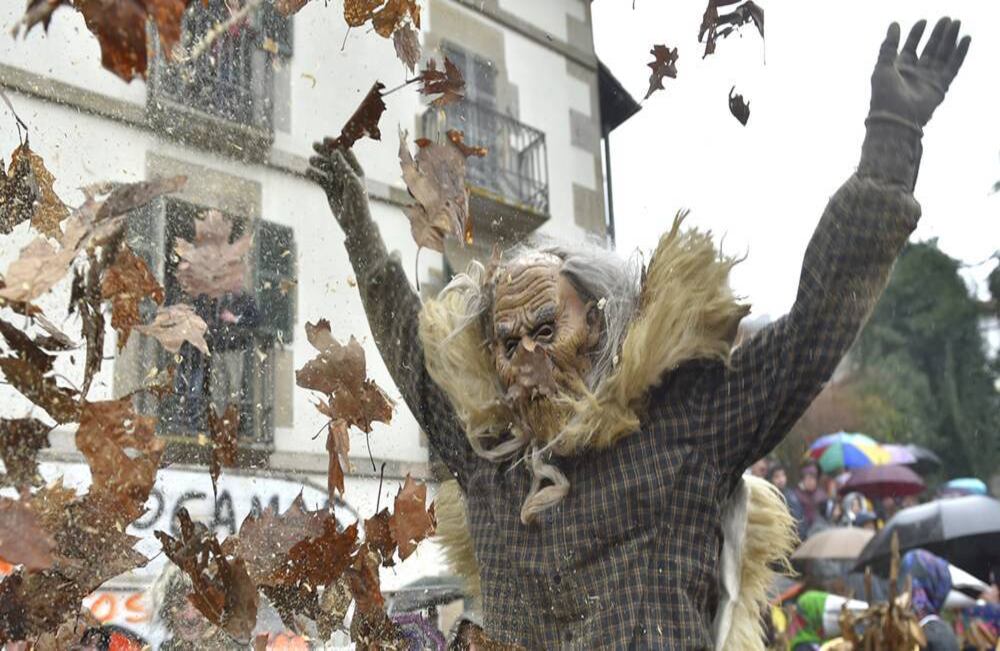 Haciendo volar hojas color café, un juerguista enmascarado participa en el antiguo carnaval de Ituren, en el norte de España, el 27 de enero de 2020. En las fiestas anuales, de tres días, los lugareños participan en una variedad de actividades, en torno a la agricultura y el pastoreo de ovejas. Foto: Ander Gillenea/ AFP. 