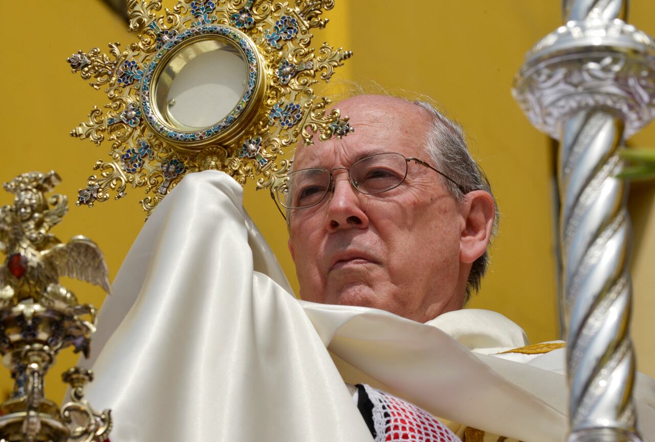 El cardenal peruano Juan Luis Cipriani alza una hostia bendita durante la celebración del Corpus Christi en la Plaza de Armas de Lima el 10 de junio de 2012. AFP PHOTO/CRIS BOURONCLE (Foto por CRIS BOURONCLE / AFP)