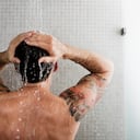 Hombre duchándose, se encuentra de espaldas, qué tan bueno es hacerlo a diario.