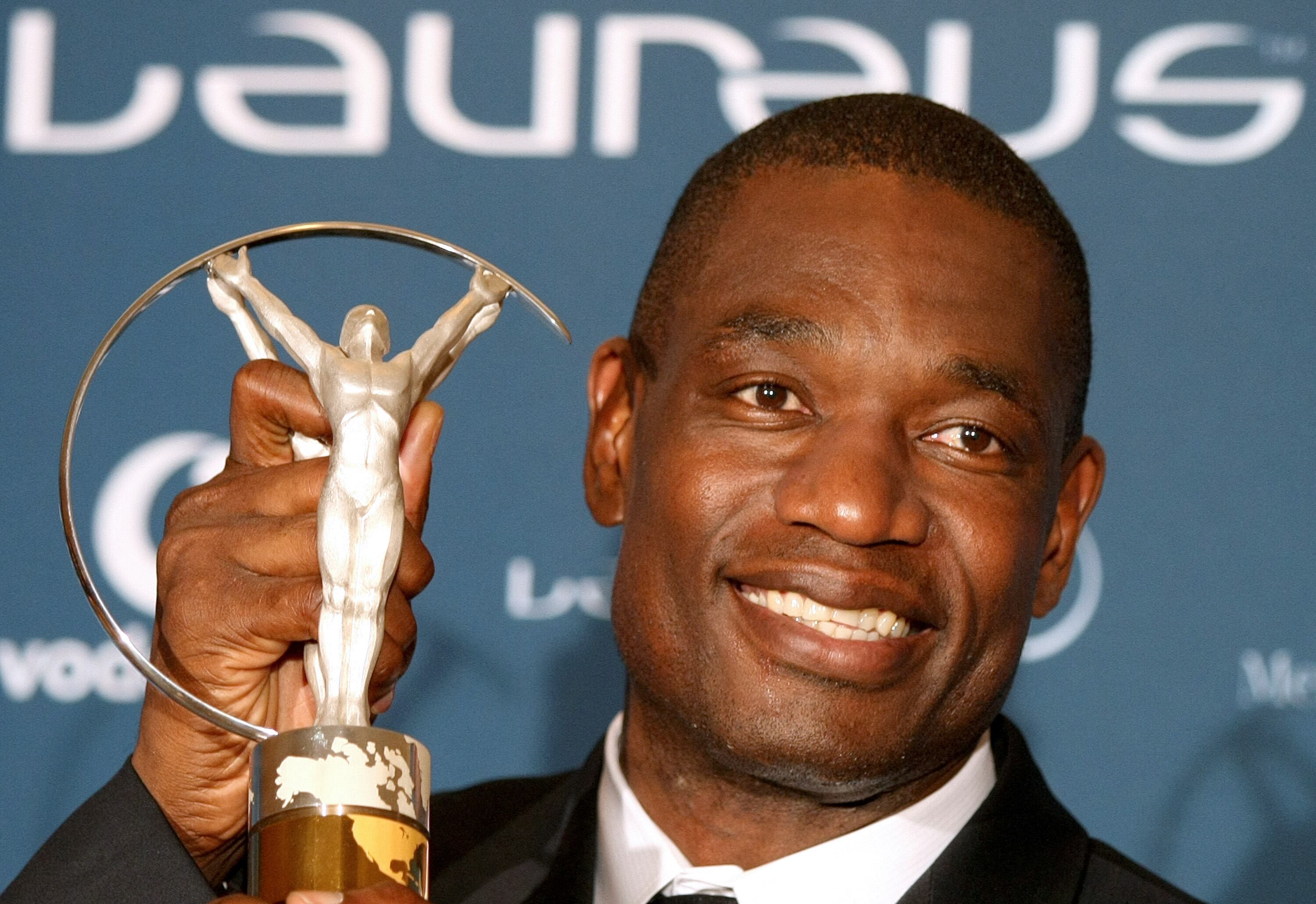 La ex estrella del baloncesto estadounidense Dikembe Mutombo posa con su premio "Sport for Good" por su trabajo caritativo en el Congo en el 2010.