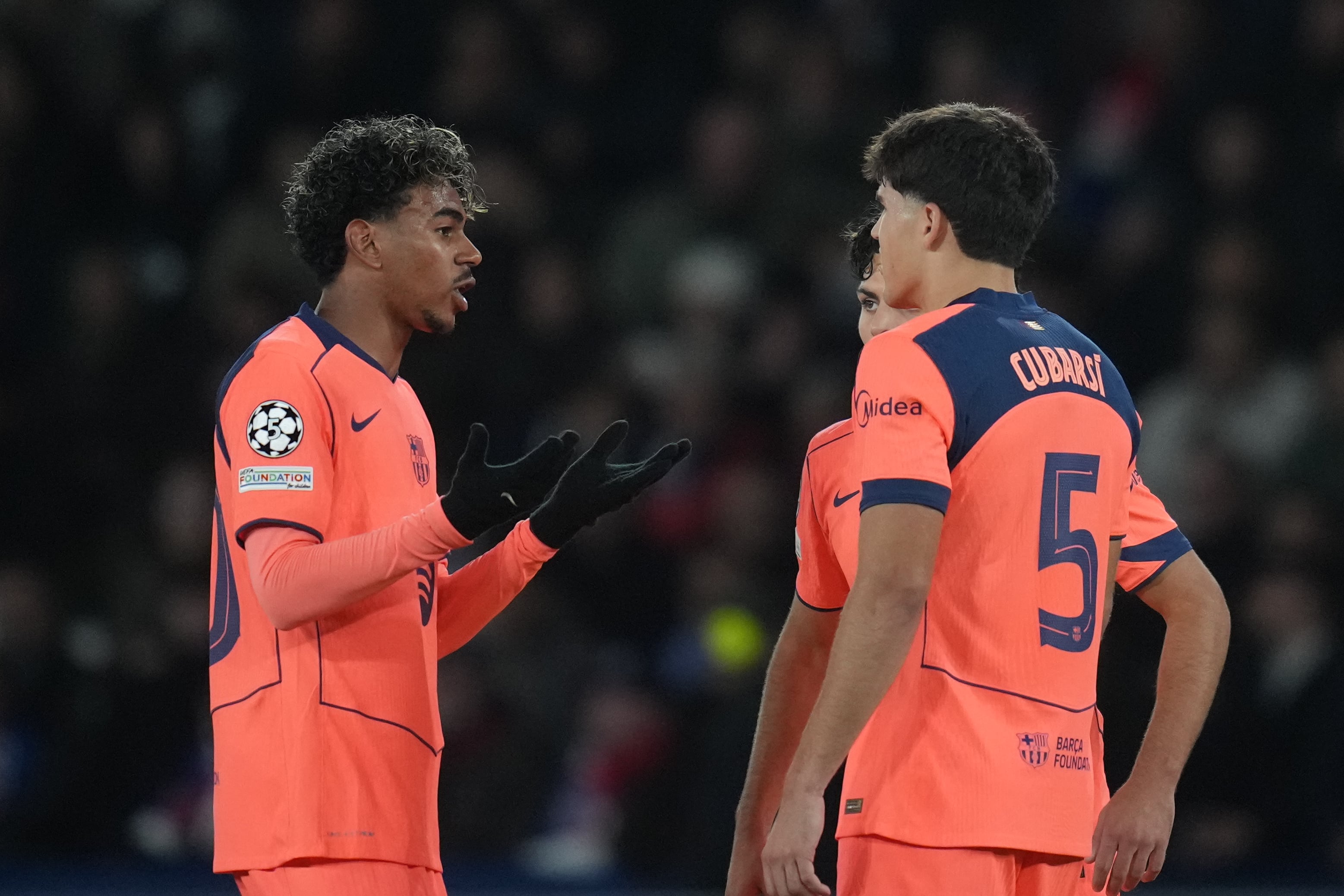 Barcelona's Lamine Yamal, left, speaks with his teammates Pau Cubarsi, right, and Xavi Espart during the Champions League opening phase soccer match between Paris Saint-Germain and FC Barcelona in Paris, Tuesday, Oct. 20, 2026. (AP Photo/Thibault Camus)
