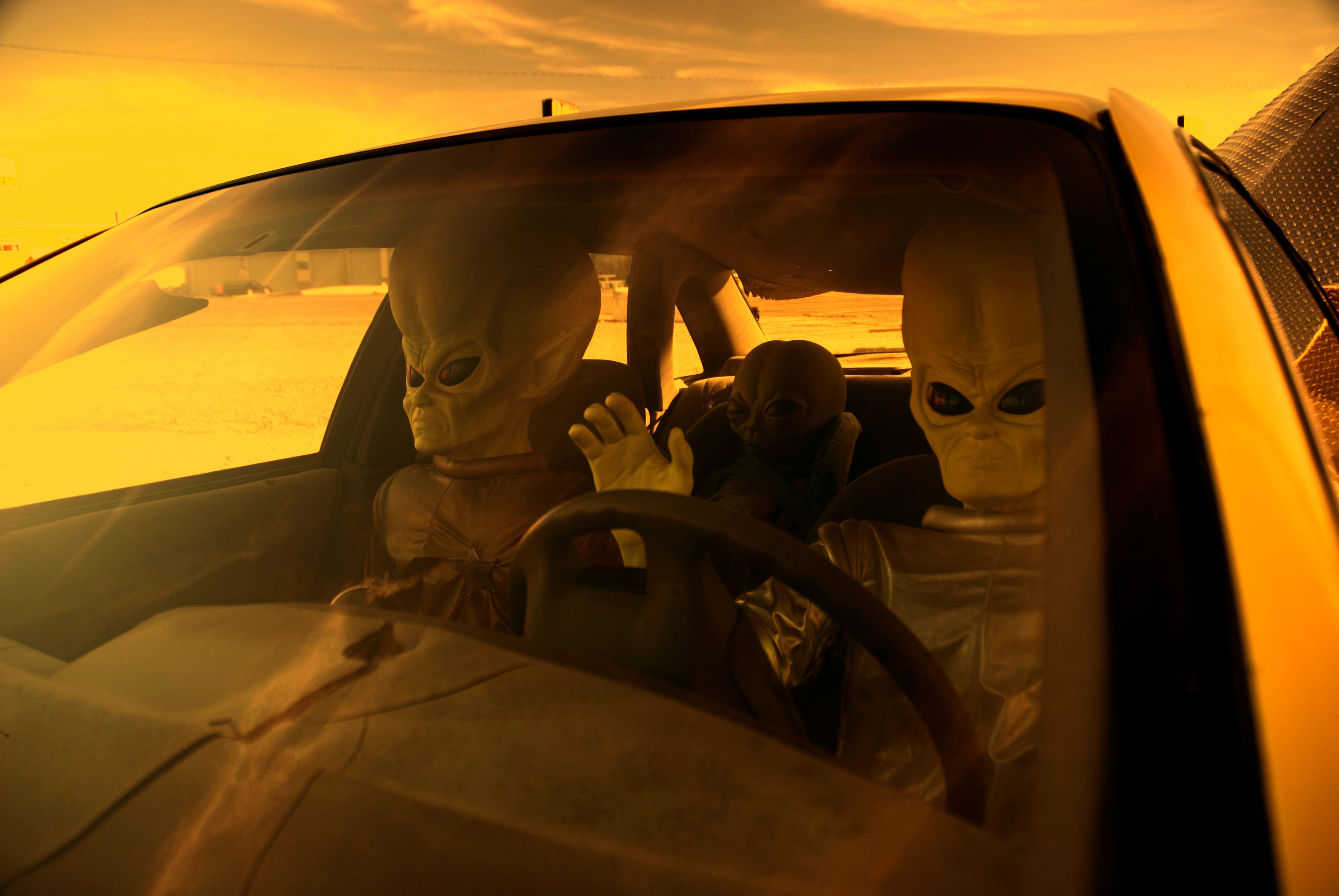 Ilustración de extraterrestres conduciendo un carro.