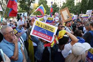 Los partidarios de la oposición venezolana sostienen carteles que dicen "Por la libertad de Venezuela" mientras se concentran frente al Parlamento español mientras los diputados españoles debaten después de que el partido de derecha español PP pidiera el reconocimiento por parte del Estado español de Edmundo González Urrutia como ganador de las elecciones venezolanas en El Congreso español en Madrid el 10 de septiembre de 2024.