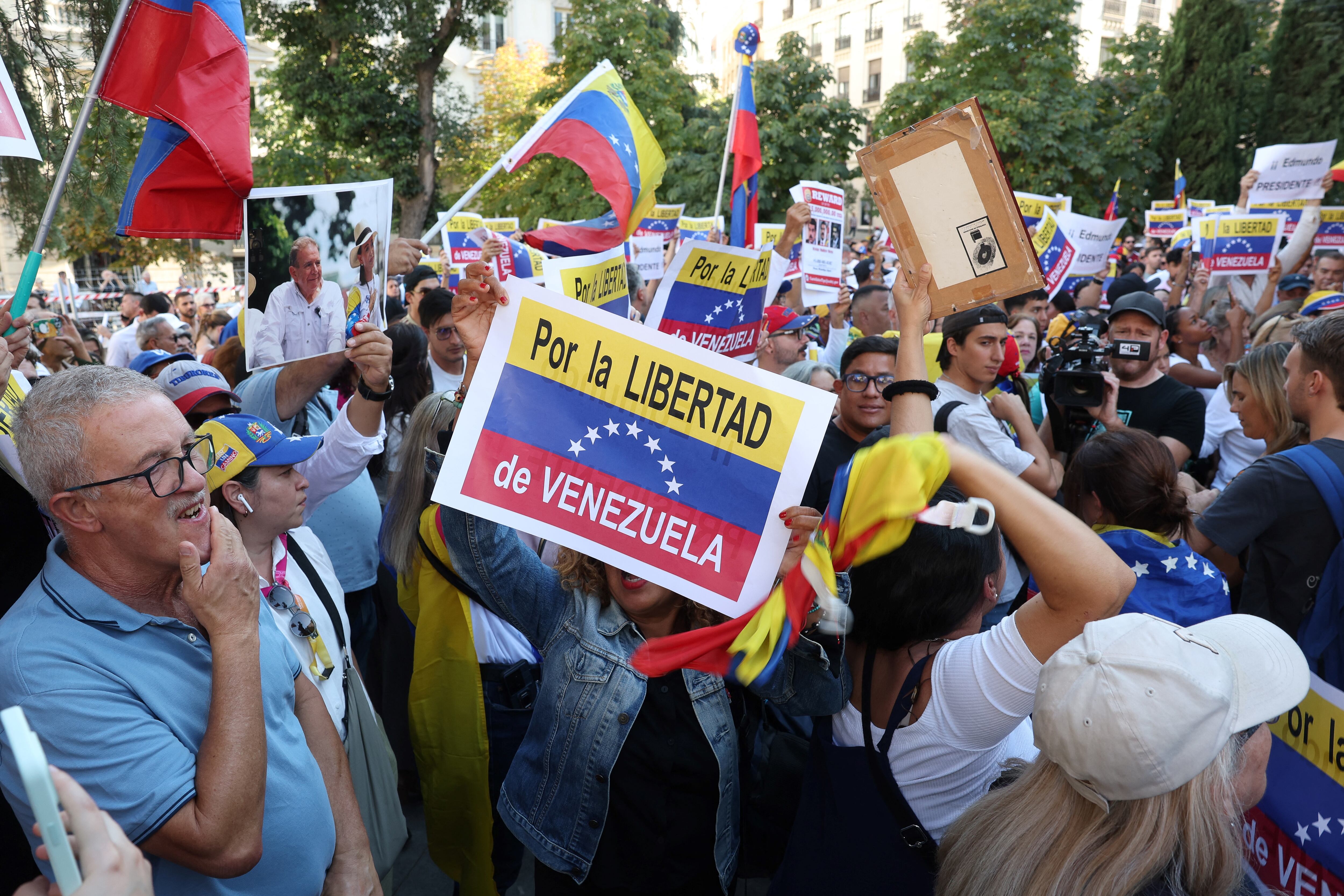 Los partidarios de la oposición venezolana sostienen carteles que dicen "Por la libertad de Venezuela" mientras se concentran frente al Parlamento español mientras los diputados españoles debaten después de que el partido de derecha español PP pidiera el reconocimiento por parte del Estado español de Edmundo González Urrutia como ganador de las elecciones venezolanas en El Congreso español en Madrid el 10 de septiembre de 2024.