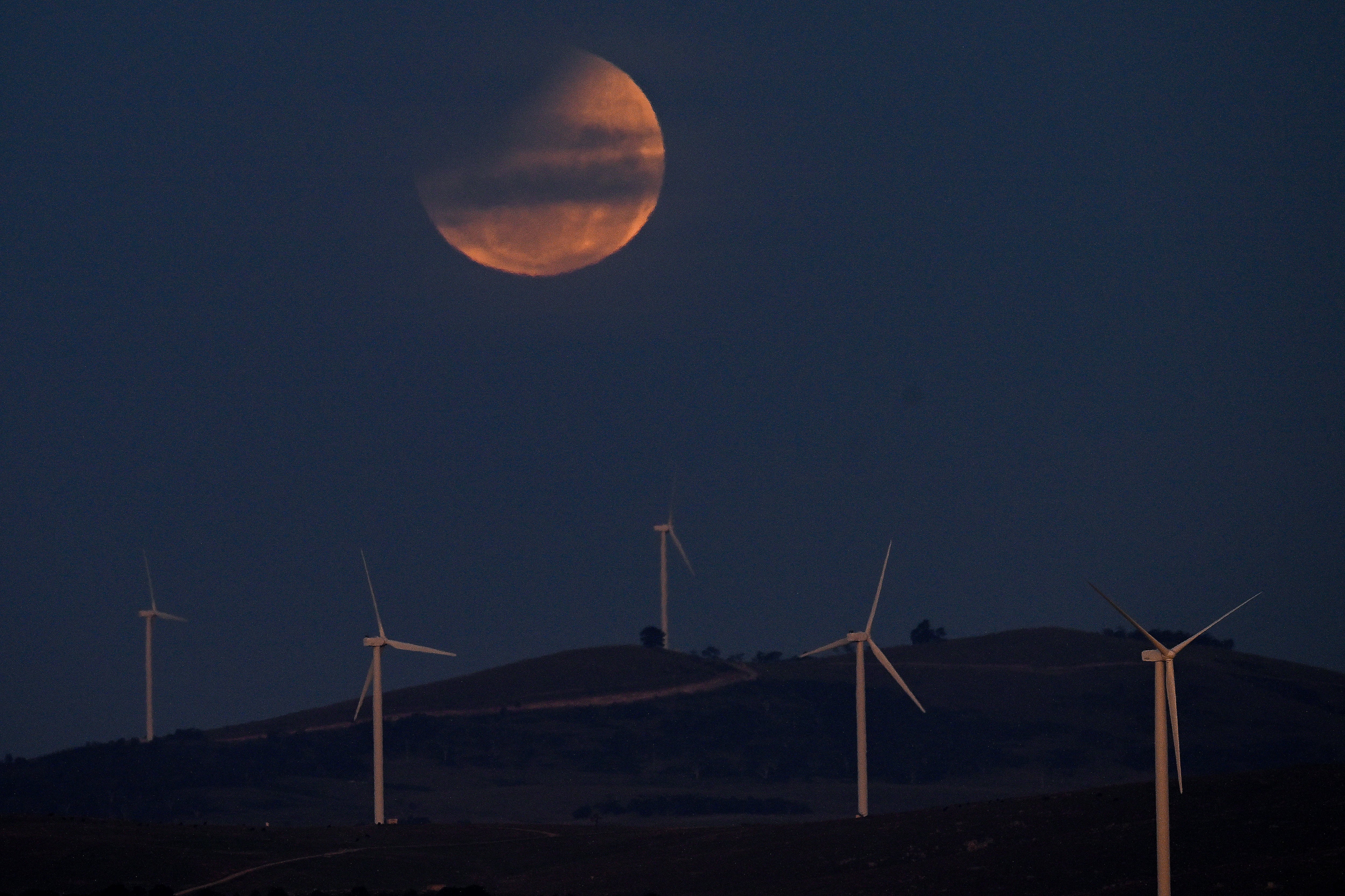 La "luna de sangre," vista de manera parcial durante el eclipse en el lago George, cerca de la capital australiana de Canberra . (Photo by Izhar KHAN / AFP)