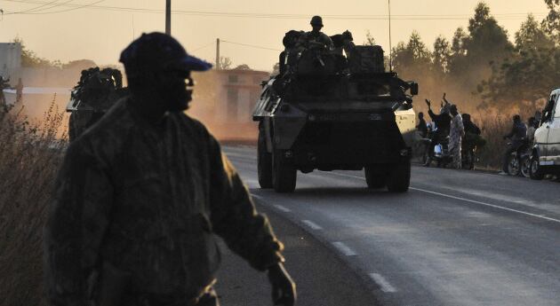 Un policía de Malí en la capital Bamako da paso a un convoy del Ejército francés que va hacia el encuentro con los guerrilleros islamistas. París prevé desplegar 2.500 soldados en el marco de la Operación Serval.