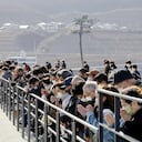 La gente observa un momento de silencio a las 2:46 p. m., el momento en que ocurrió el terremoto en Rikuzentakata, prefectura de Iwate el sábado 11 de marzo de 2023. (Kyodo News via AP)