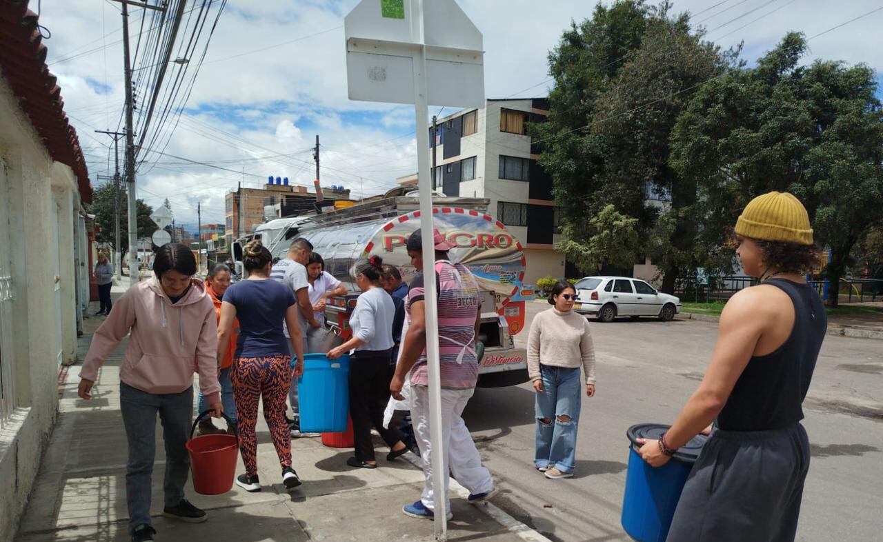 Carrotanques suministrando agua al barrio Modelia, al que aún no llega el líquido tras el racionamiento.