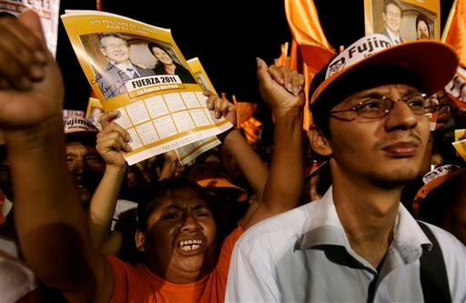 Seguidores del ex presidente de Perú, Alberto Fujimori, y de su hija Keiko (candidata presidencial) agitan carteles de apoyo en una de las calles de Lima.  
