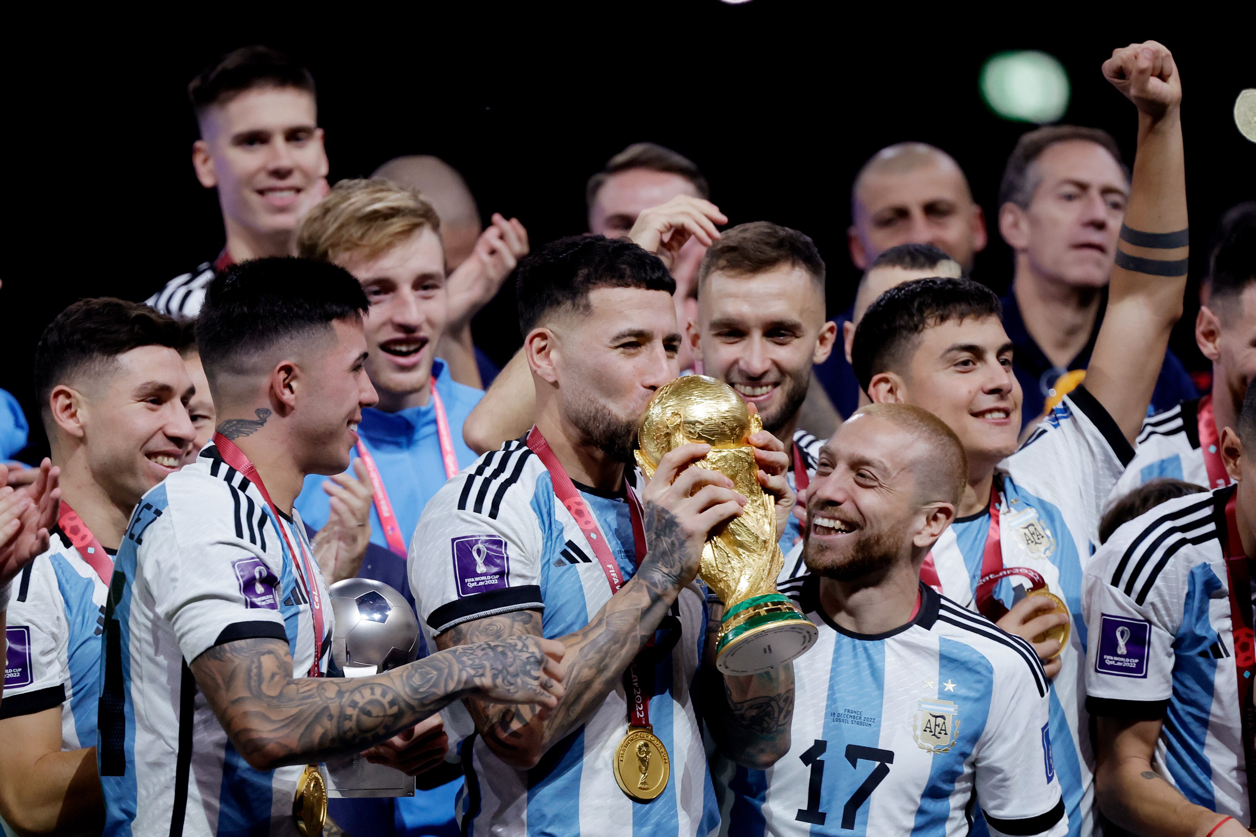 LUSAIL CITY, QATAR - DECEMBER 18: Nicolas Otamendi of Argentina celebrates the World Cup victory with the trophy with Papu Gomez of Argentina, German Pezzella of Argentina Guido Rodriguez of Argentina, Paulo Dybala of Argentina, Enzo Fernandez of Argentina, Lionel Messi of Argentina, Gonzalo Montiel of Argentina  during the  World Cup match between Argentina  v France at the Lusail Stadium on December 18, 2022 in Lusail City Qatar (Photo by Eric Verhoeven/Soccrates/Getty Images)