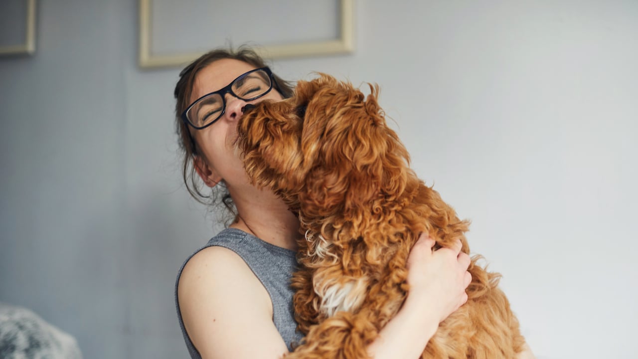 Mujer recibe un beso de su perrito.
