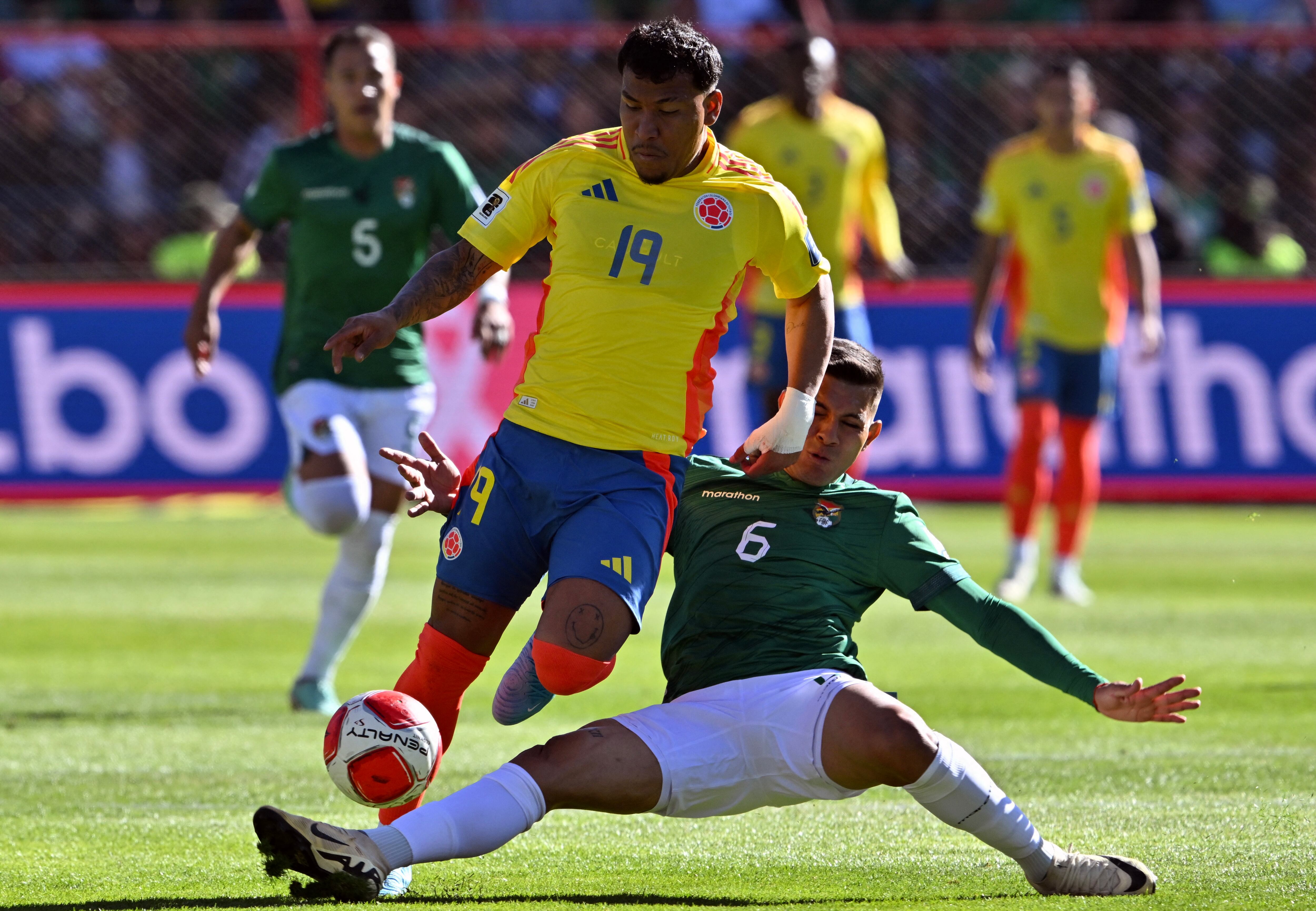 Colombia's Roger Martinez (L) and Bolivia's defender Hector Cuellar fight for the ball during the 2026 FIFA World Cup South American qualifiers football match between Bolivia and Colombia, at the Municipal stadium in El Alto, Bolivia on October 10, 2024. (Photo by AIZAR RALDES / AFP)