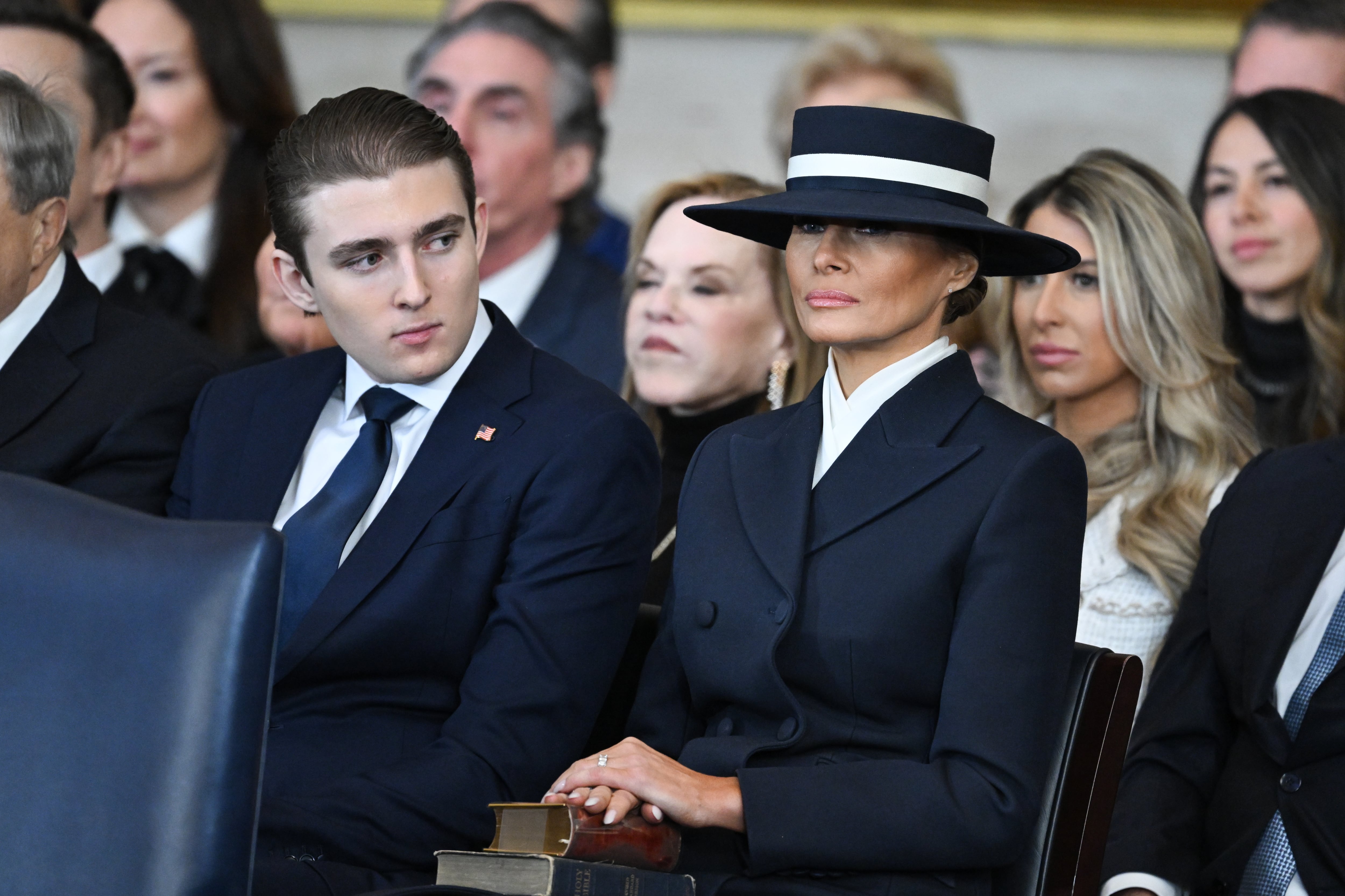WASHINGTON, DC - JANUARY 20:  Barron Trump and first lady Melania Trump listen as President Donald Trump gives his inaugural address in the U.S. Capitol Rotunda on January 20, 2025 in Washington, DC. Donald Trump takes office for his second term as the 47th president of the United States. (Photo by Saul Loeb - Pool/Getty Images)