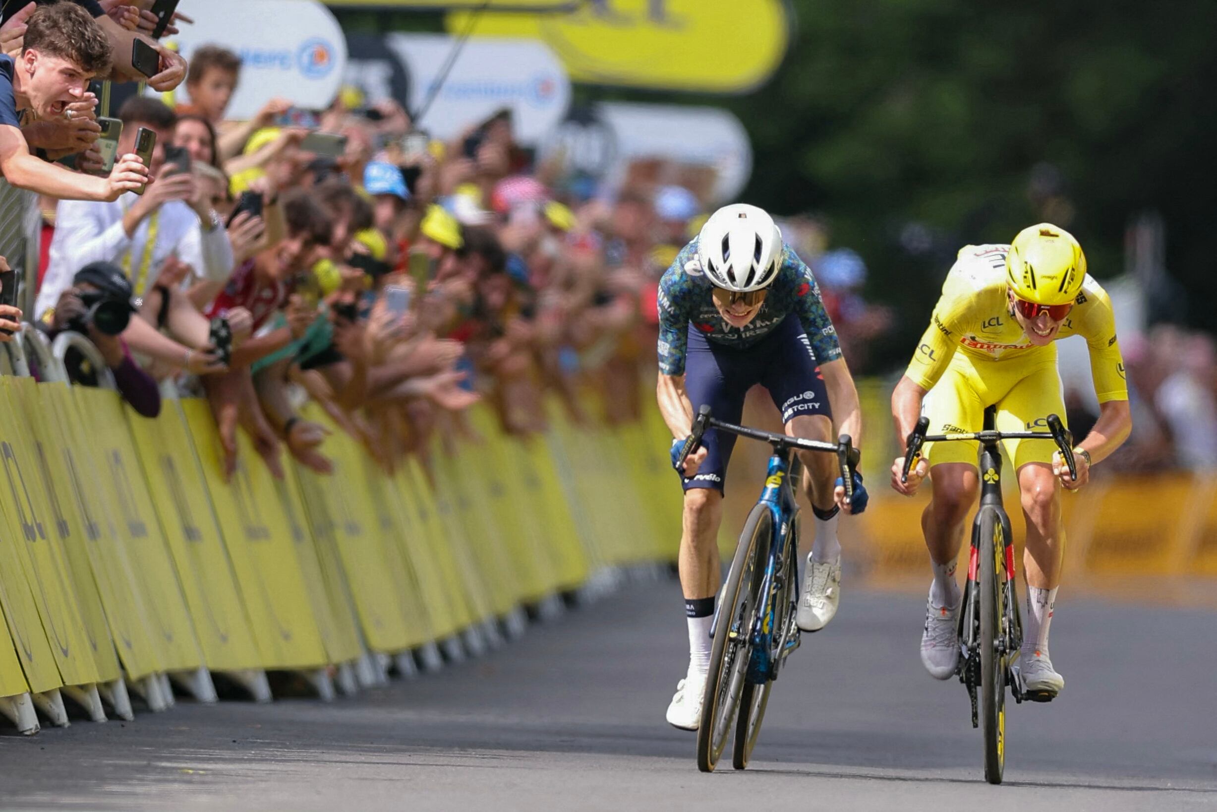 Team Visma - Lease a Bike team's Danish rider Jonas Vingegaard (L) and UAE Team Emirates team's Slovenian rider Tadej Pogacar wearing the overall leader's yellow jersey sprint to the finish line of the 11th stage of the 111th edition of the Tour de France cycling race, 211 km between �vaux-les-Bains and Le Lioran, on July 10, 2024. (Photo by Thomas SAMSON / AFP)