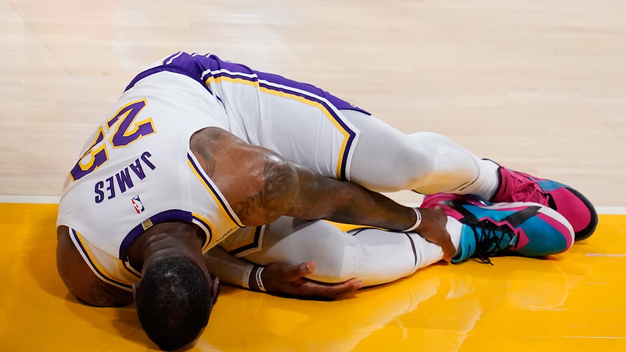 El alero de Los Angeles Lakers, LeBron James, se sostiene el tobillo después de sufrir una lesión durante la primera mitad de un partido de baloncesto de la NBA contra los Atlanta Hawks el sábado 20 de marzo de 2021 en Los Ángeles. (Foto AP / Marcio José Sánchez)