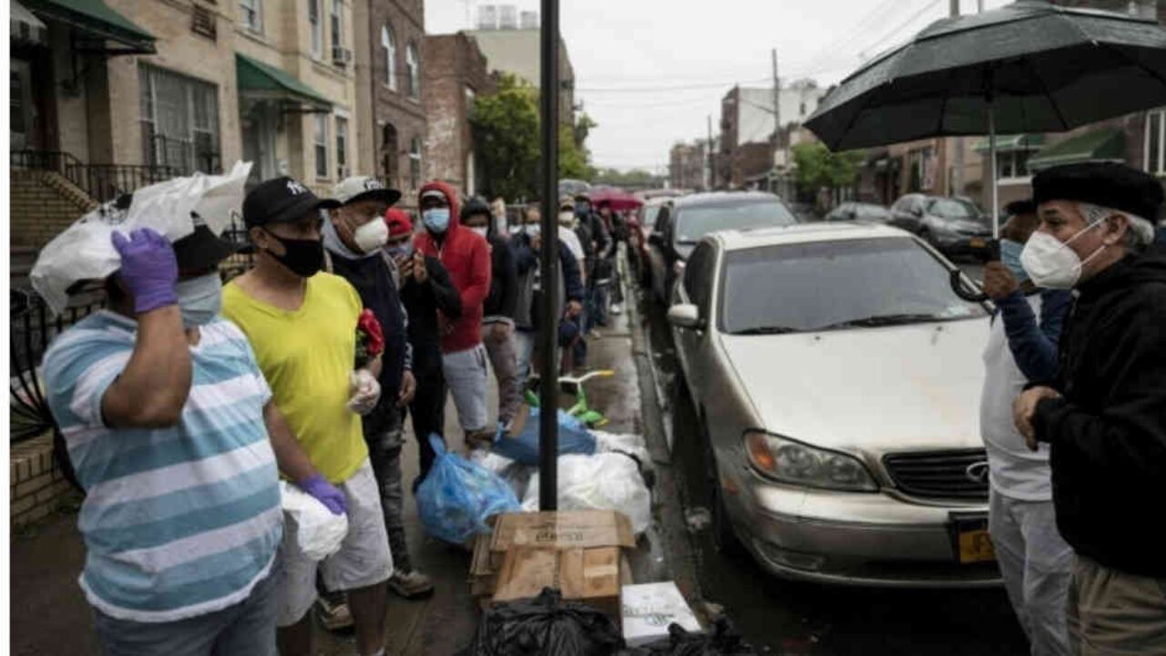El padre Fabián Arias, un pastor luterano de la Iglesia de San Pedro en Manhattan que ayuda a inmigrantes, habla con guatemaltecos que aguardan una distribución gratuita de alimentos en la ciudad de Nueva York el 22 de mayo de 2020
