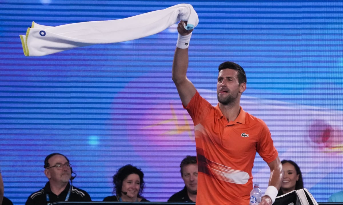 Serbia's Novak Djokovic swings his towel as he dances between games during an exhibition match against Australia's Nick Kyrgios on Rod Laver Arena ahead of the Australian Open tennis championship in Melbourne, Australia, Friday, Jan. 13, 2023. (AP/Mark Baker)