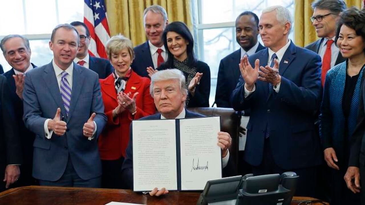 Donald Trump, junto a sus asesores, muestra una nueva orden ejecutiva.
