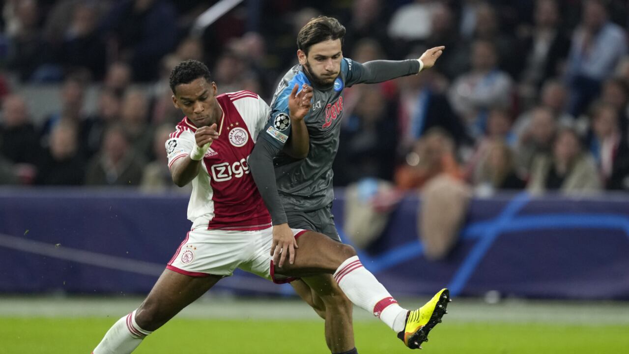 Ajax's Jurrien Timber, left, challenges Napoli's Khvicha Kvaratskhelia during the Champions League group A soccer match between Ajax and Napoli at the Johan Cruyff ArenA in Amsterdam, Netherlands, Tuesday, Oct. 4, 2022. (AP Photo/Peter Dejong)